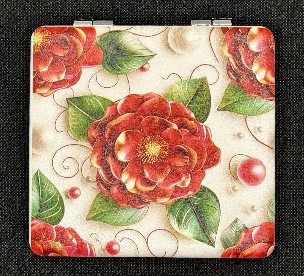 Closed Red Camellia Flower bead case on dark fabric