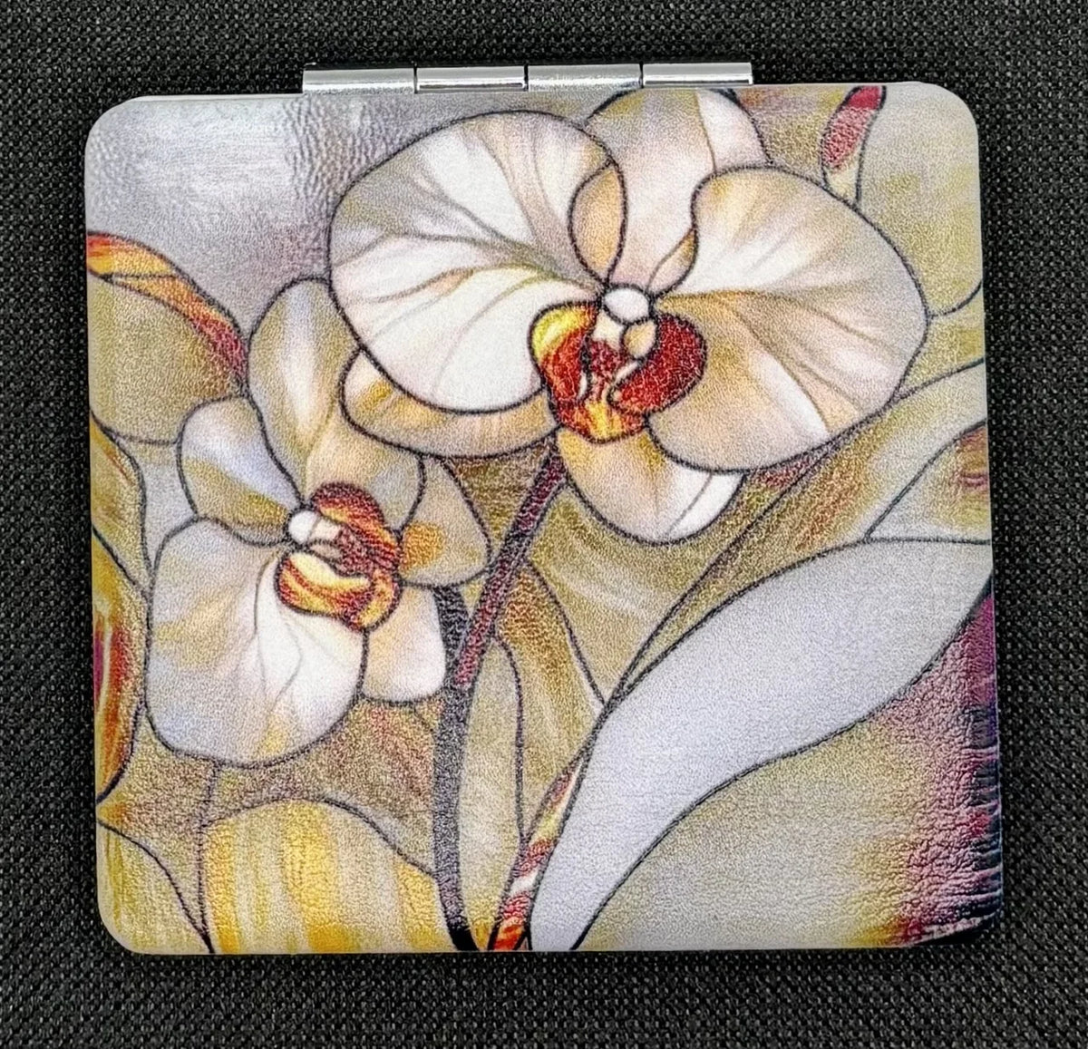 Closed Stain Glass Orchids bead case on dark fabric