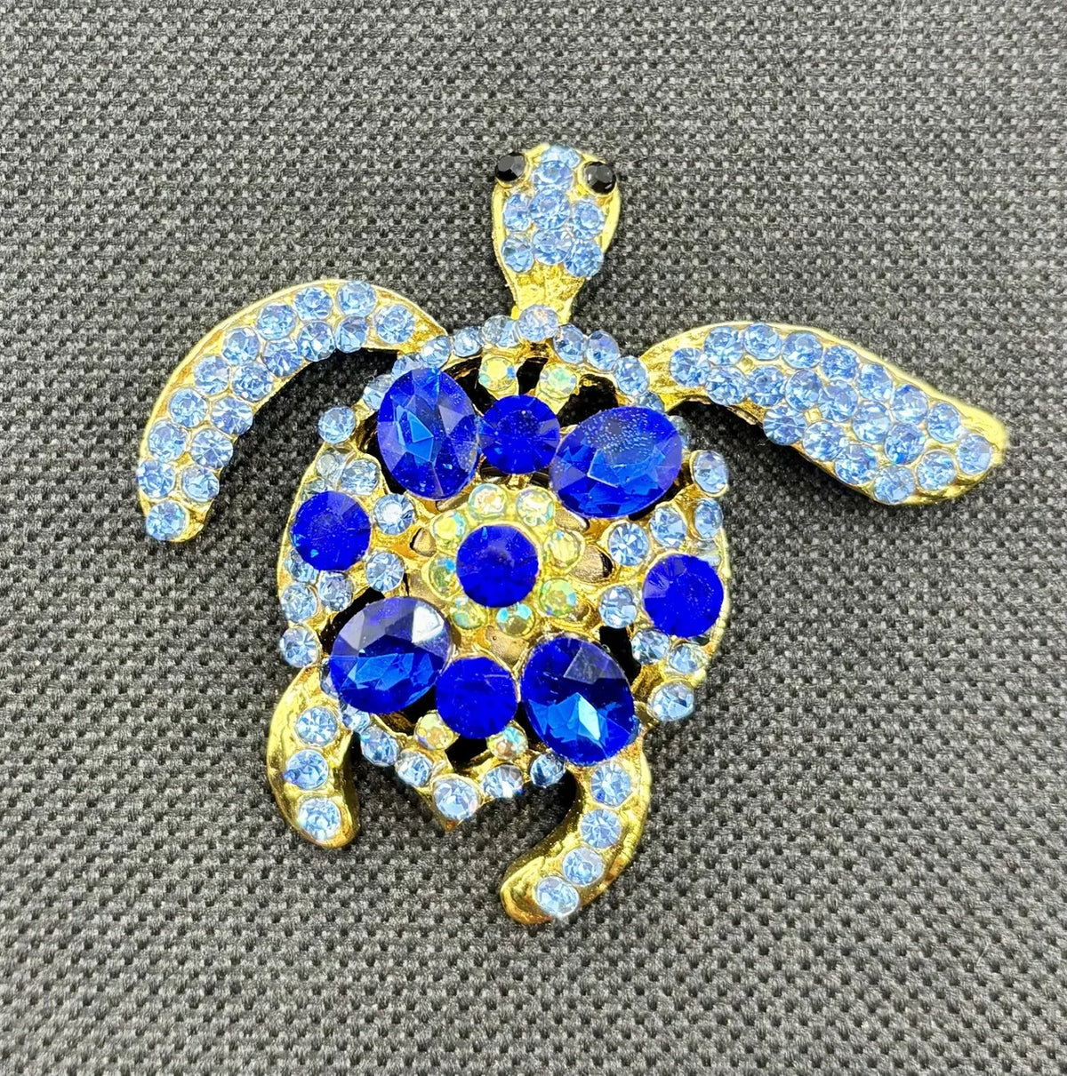 Blue sea turtle needle minder on dark fabric