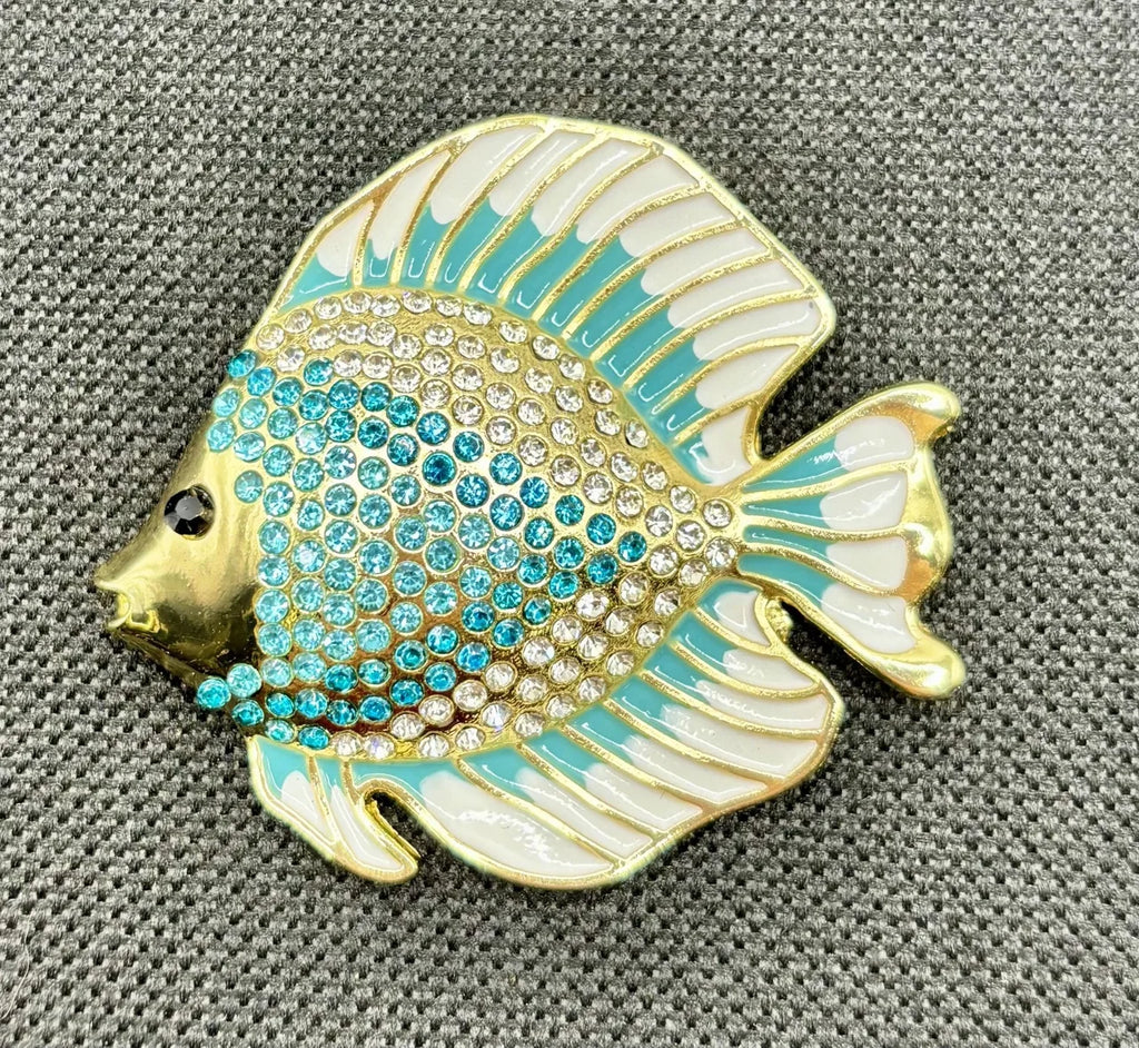 Blue and white crystal discus fish needle minder on dark fabric