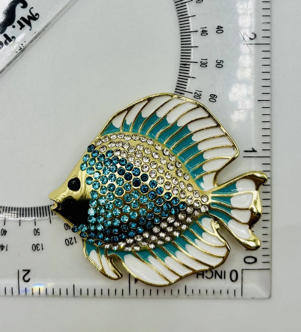 Blue and white crystal discus fish needle minder beside a ruler for scale