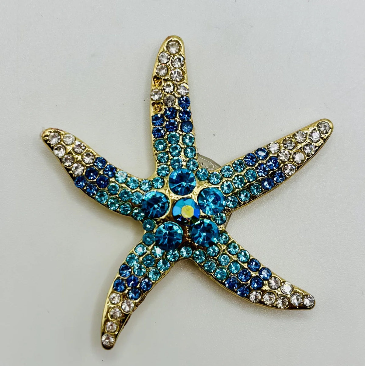 Blue crystal starfish needle minder on a white background