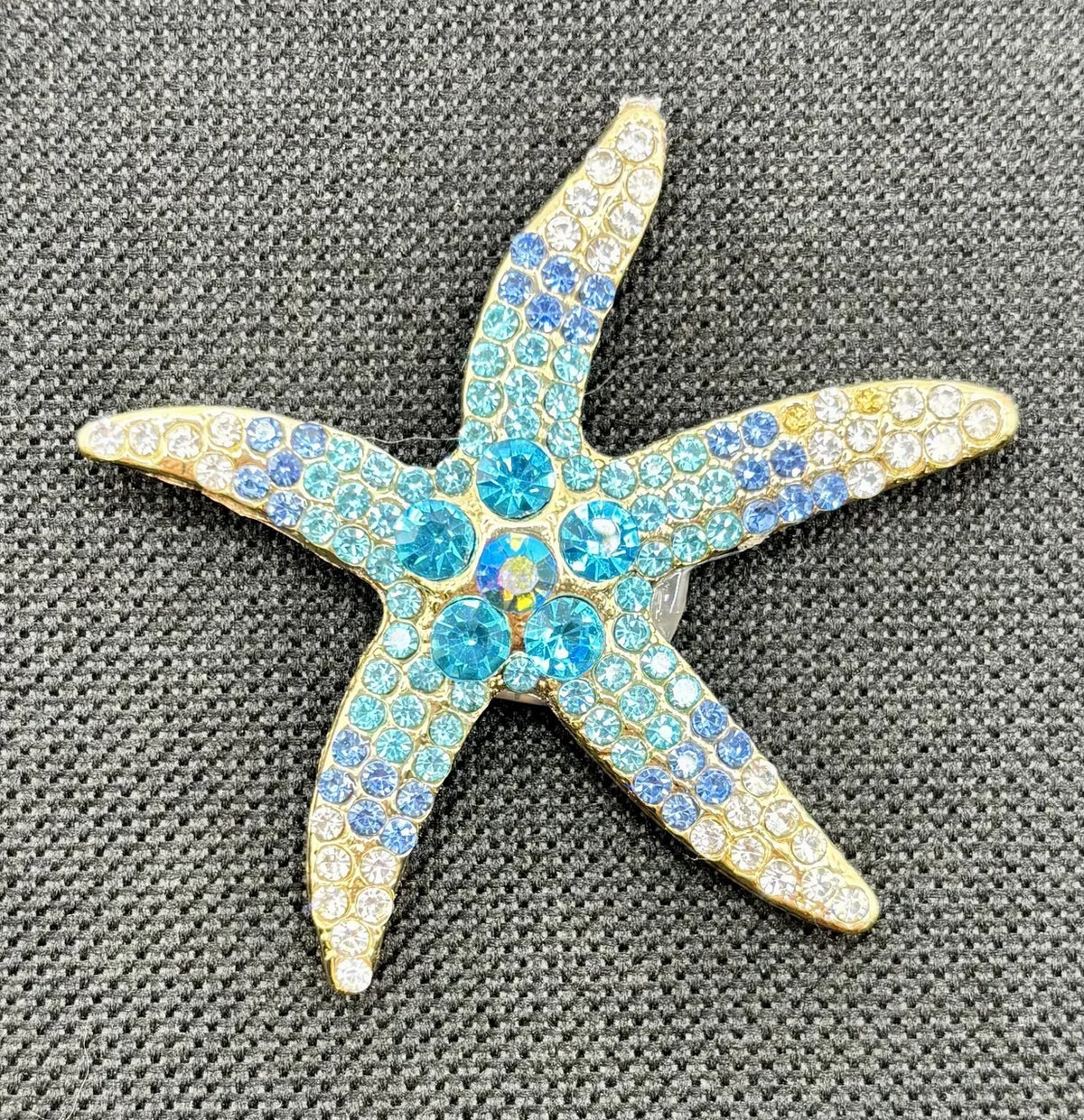 Blue crystal starfish needle minder on dark fabric
