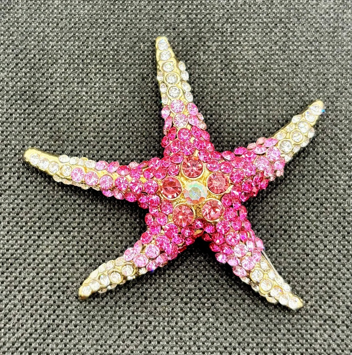 Pink crystal starfish needle minder on dark fabric