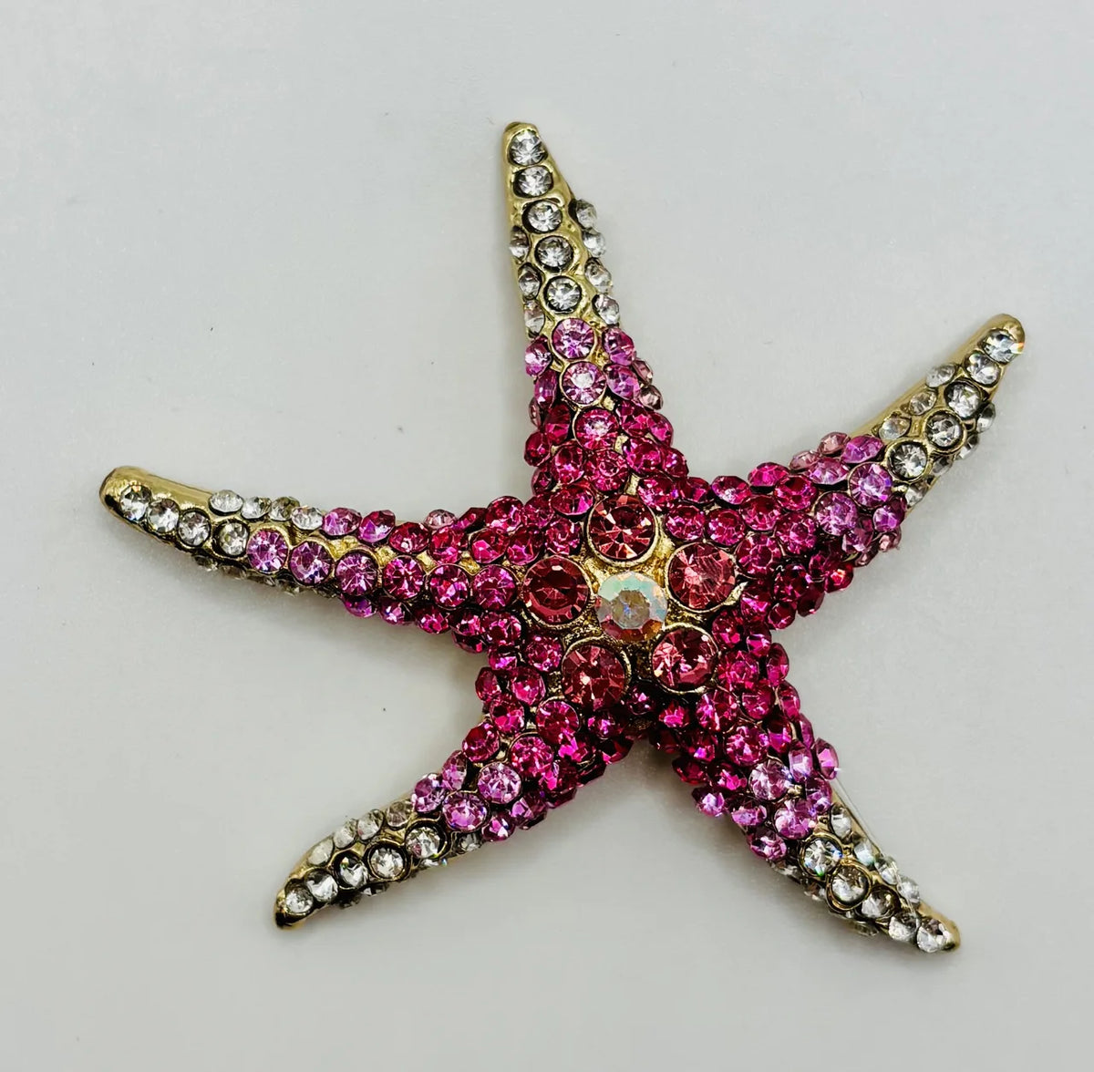 Pink crystal starfish needle minder on a white background