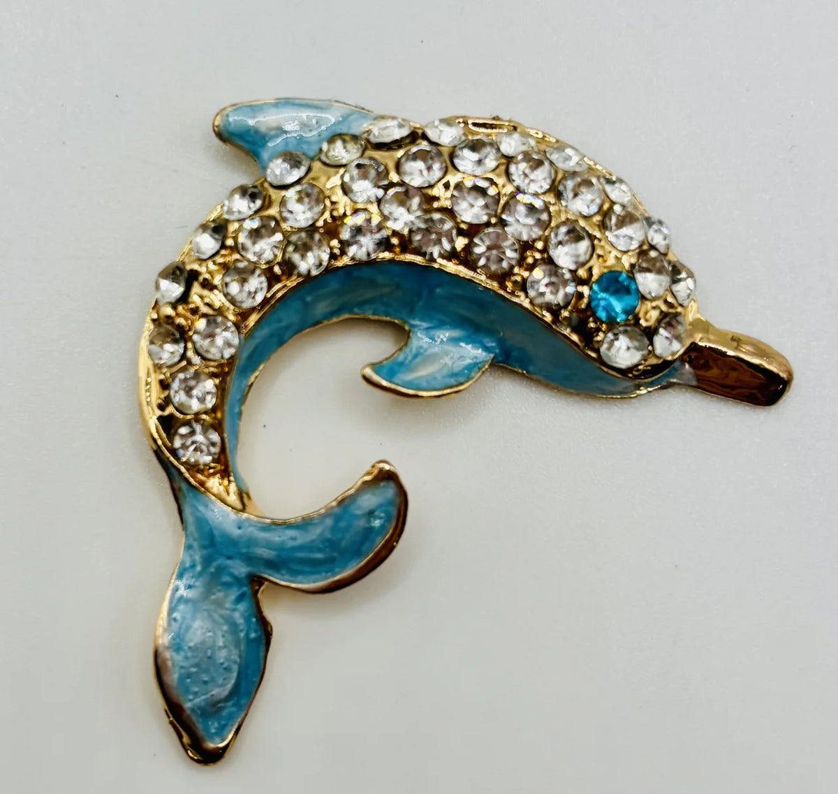 Blue crystal dolphin needle minder on a white background