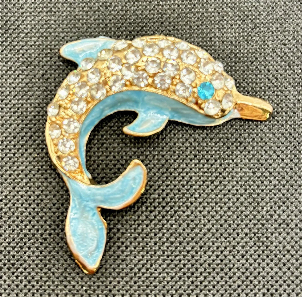 Blue crystal dolphin needle minder on dark fabric