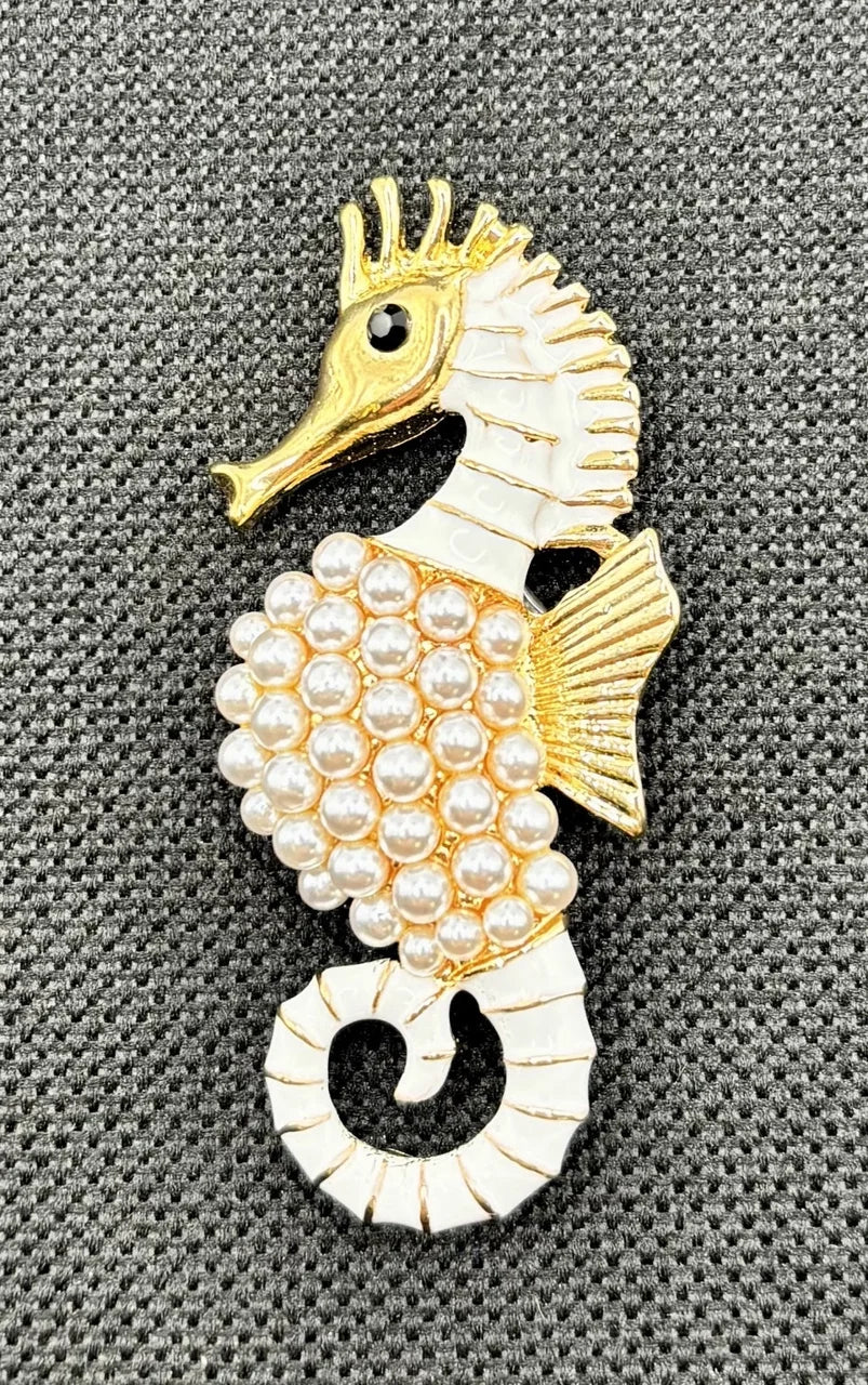Gold and pearl seahorse needle minder on dark fabric