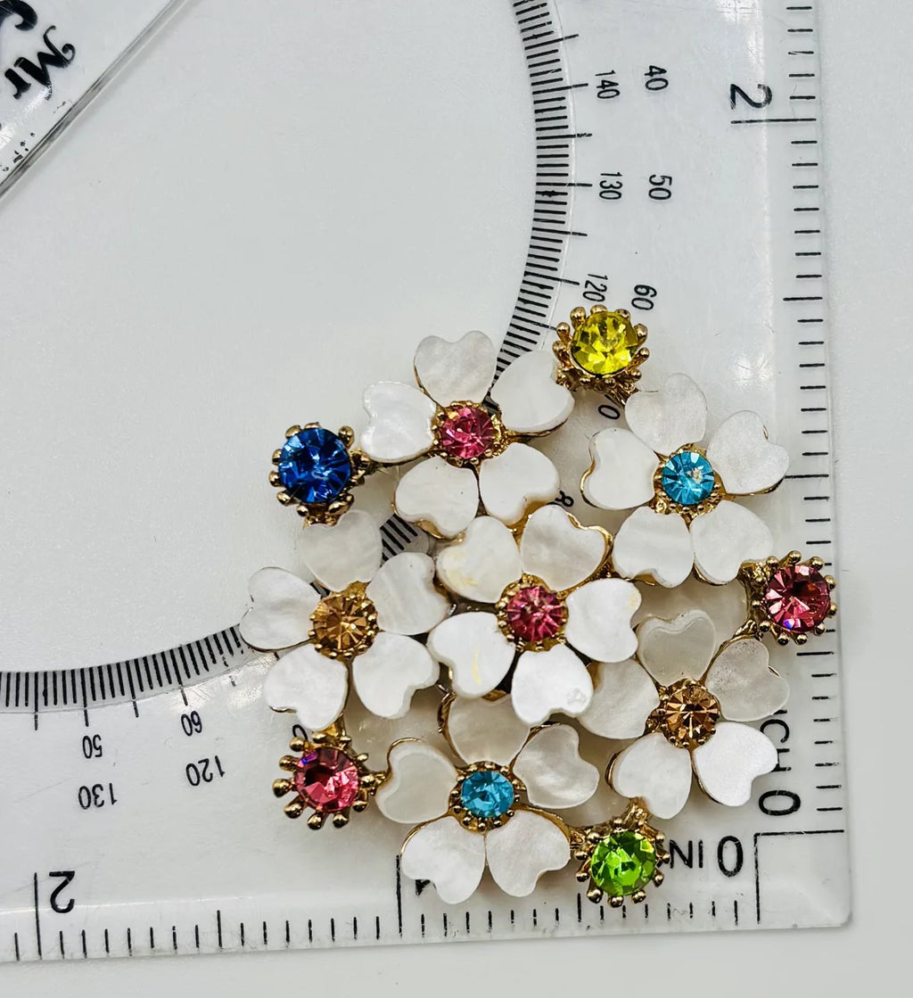 Crystal white posey needle minder beside a ruler for scale