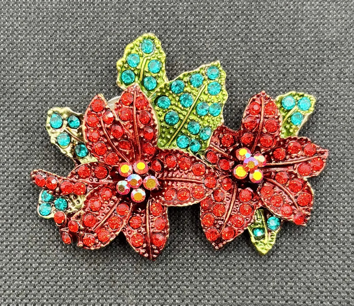 Crystal red poinsettia needle minder on dark fabric