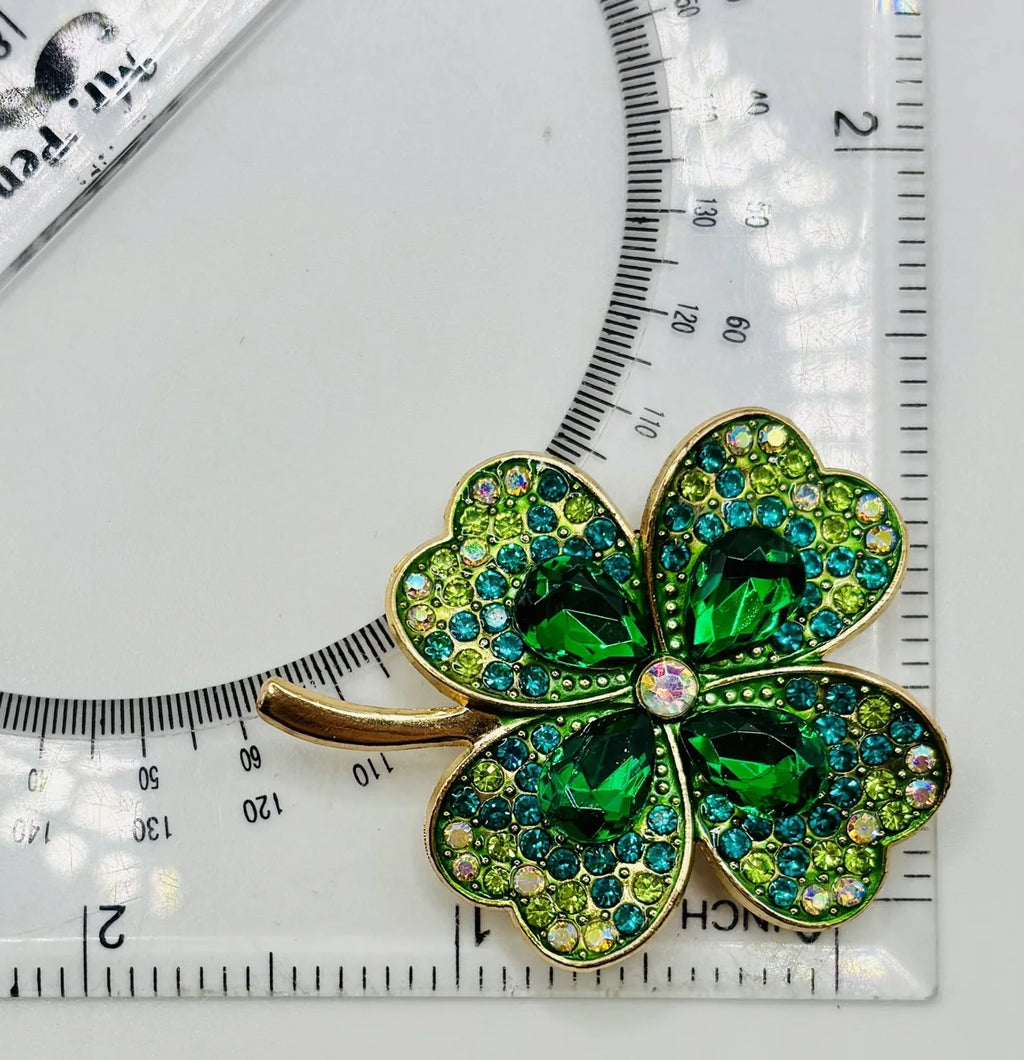 Large crystal shamrock needle minder beside a ruler for scale