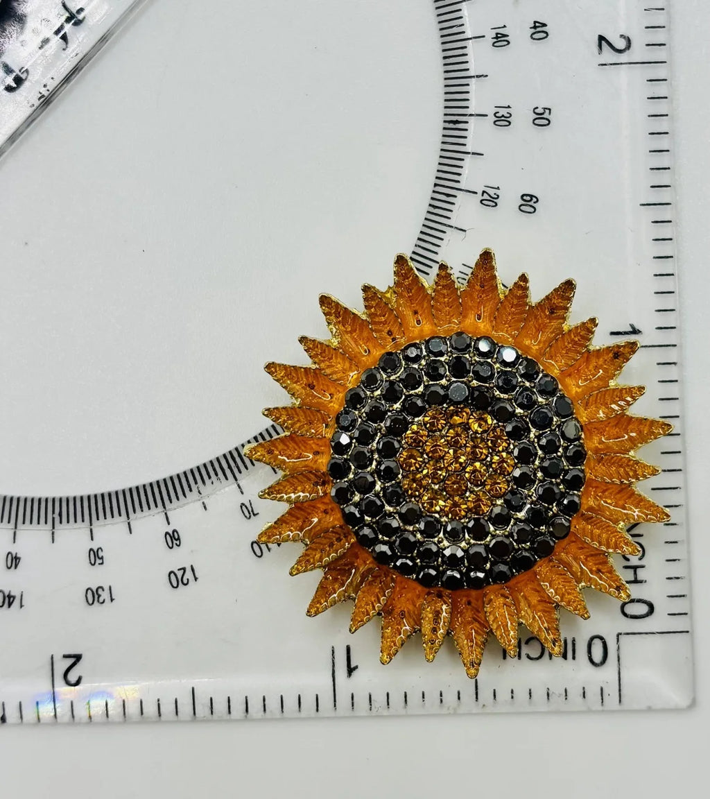 Crystal sunflower needle minder beside a ruler for scale