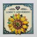 Oil dripped sunflower with crystal needle minder on Ginny’s Gem Minders display card