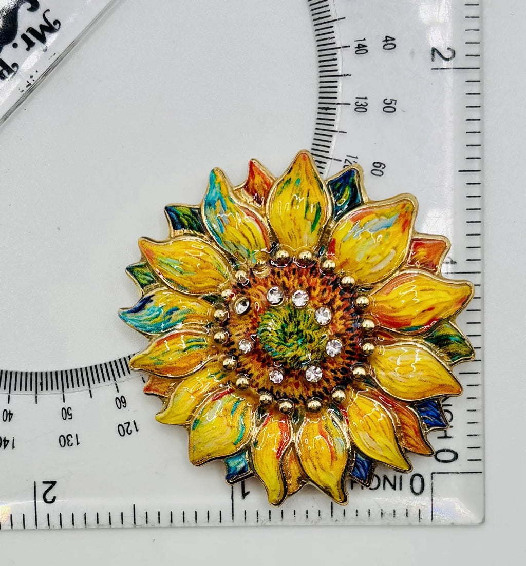 Oil dripped sunflower with crystal needle minder beside a ruler for scale