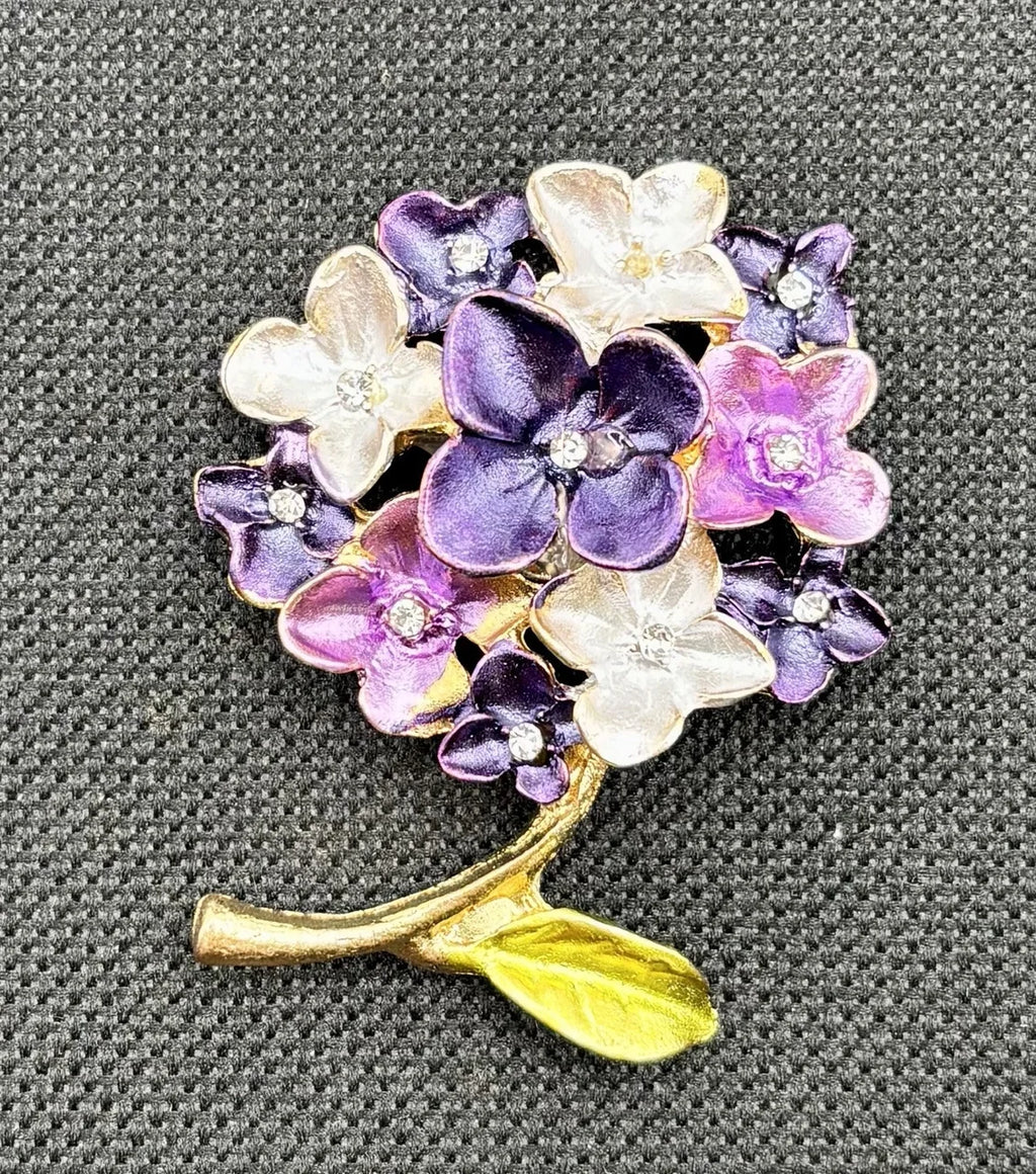 Purple enamel hydrangea needle minder on dark fabric