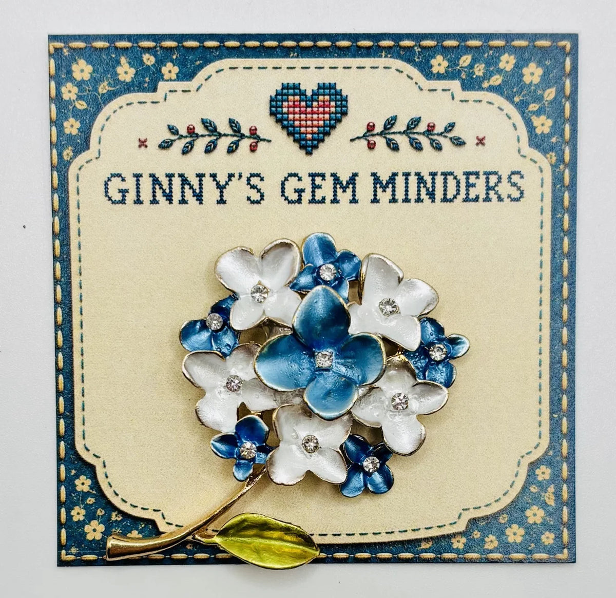 Blue and white enamel needle minder on Ginny’s Gem Minders display card
