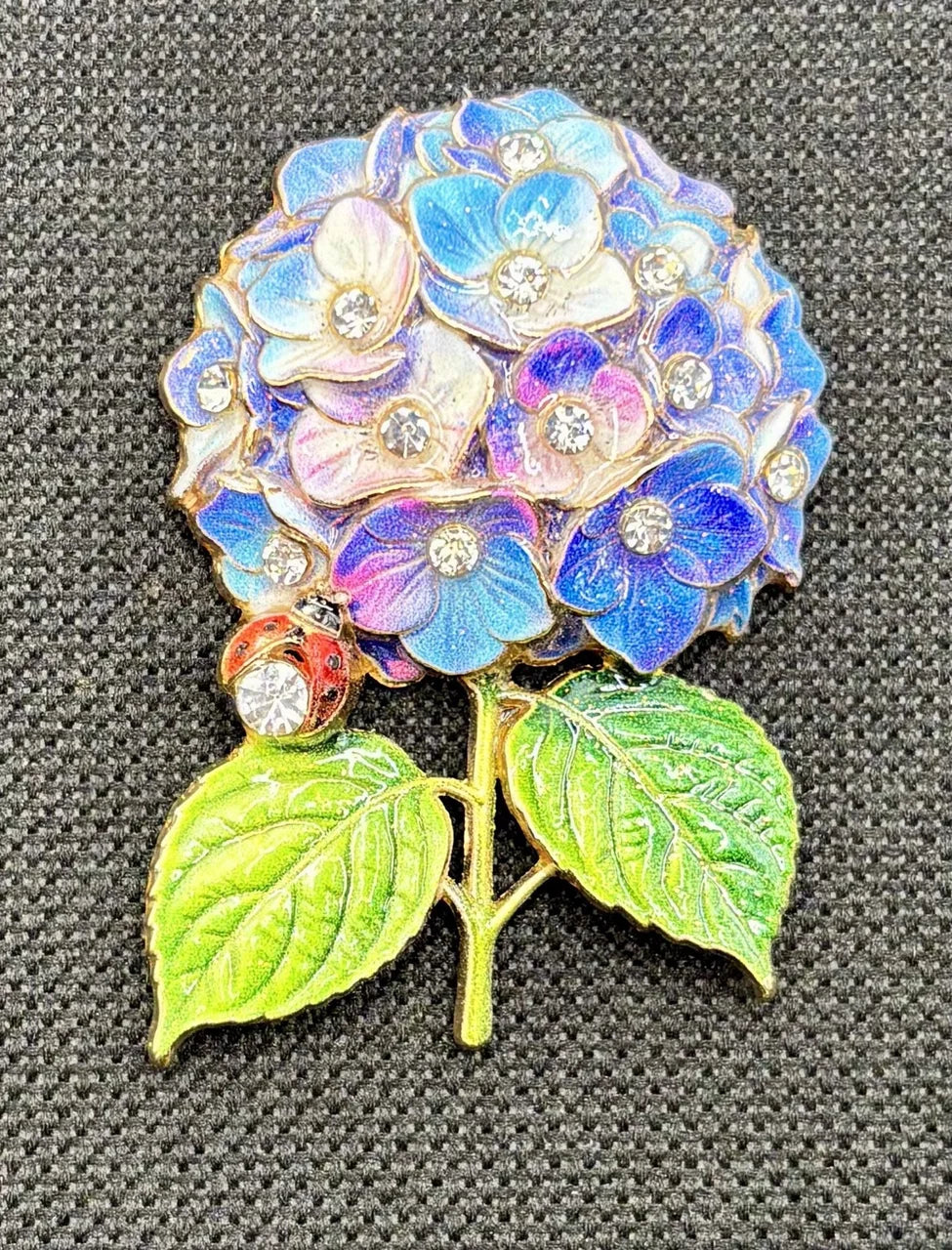 Blue and lavender hydrangea needle minder on dark fabric