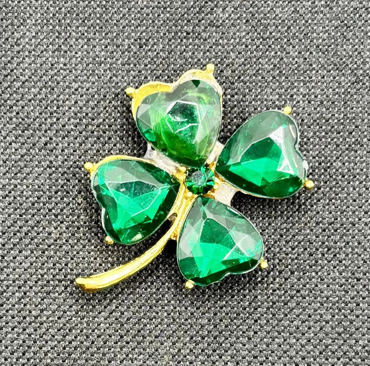 Small crystal shamrock needle minder on dark fabric