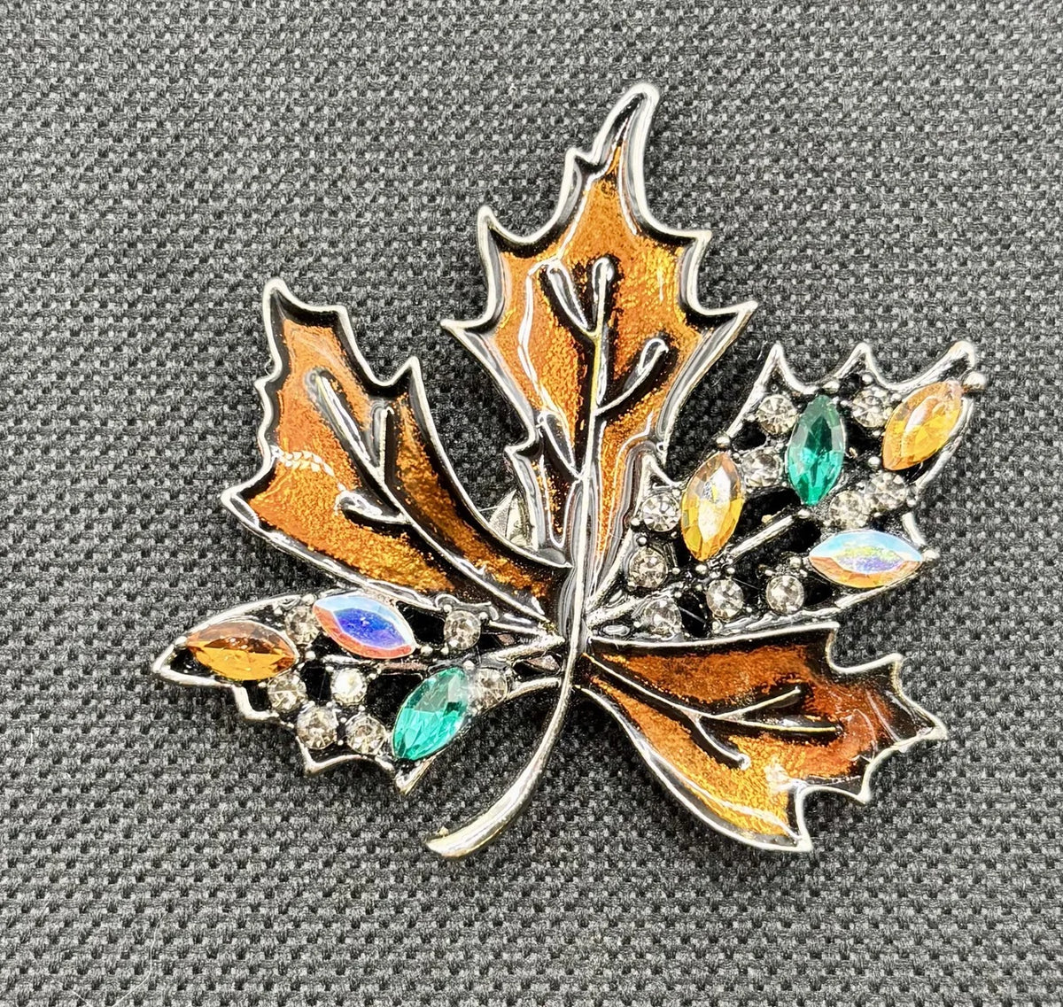 Bronze crystal leaf needle minder on dark fabric