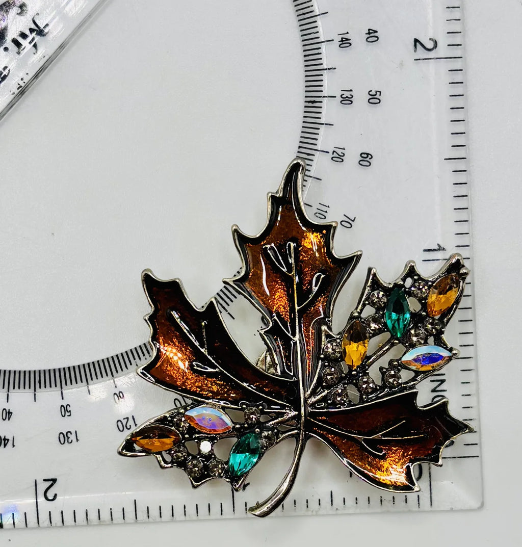 Bronze crystal leaf needle minder beside a ruler for scale
