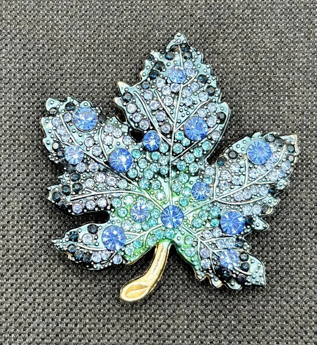 Blue crystal leaf needle minder on dark fabric
