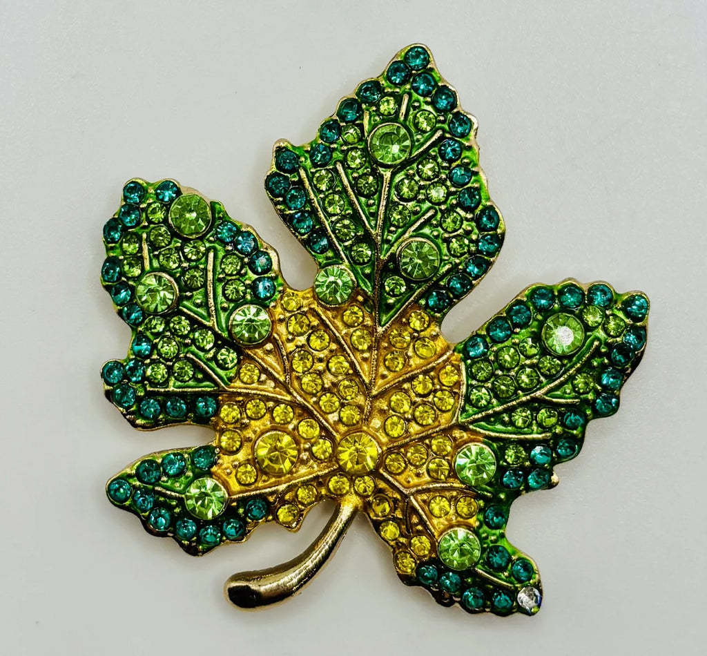 Green and yellow crystal leaf needle minder on a white background