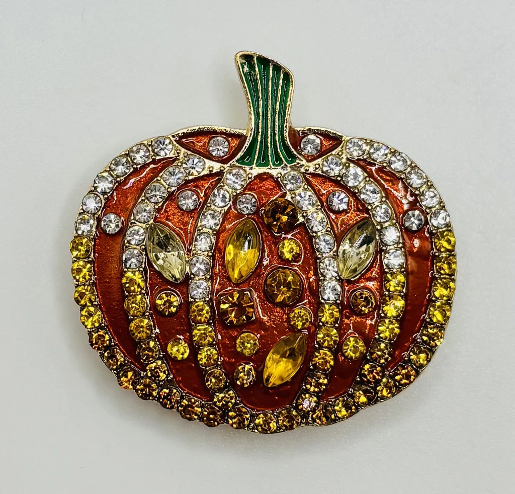 Orange enamel and crystal pumpkin needle minder on a white background