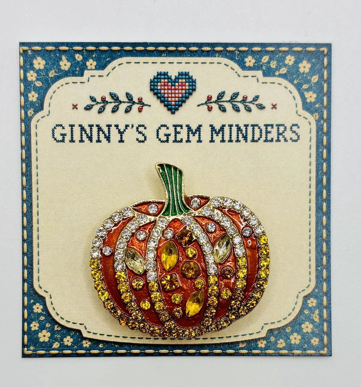 Orange enamel and crystal pumpkin needle minder on Ginny’s Gem Minders display card