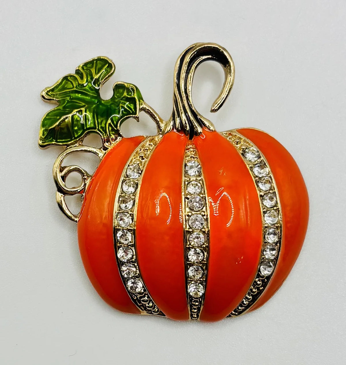 Large enamel pumpkin with crystals needle minder on a white background