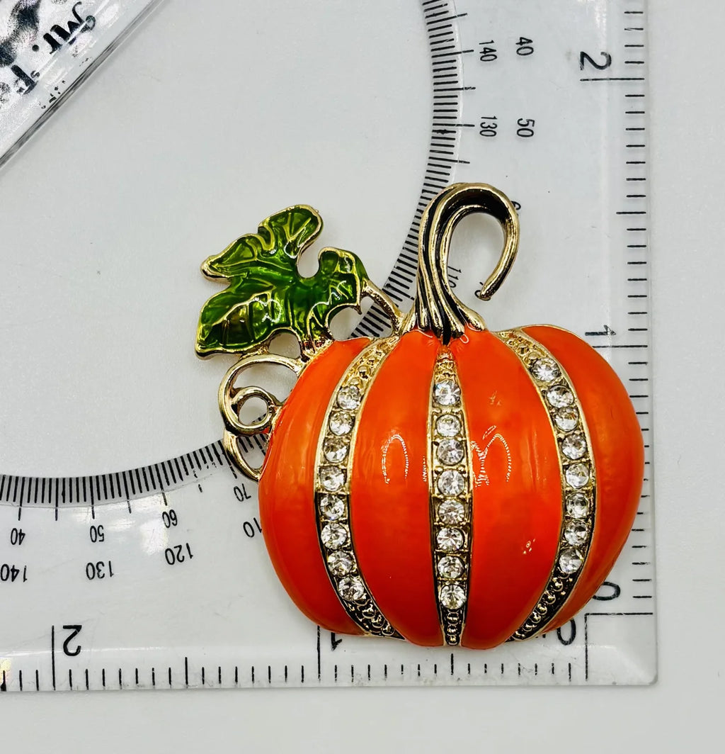 Large enamel pumpkin with crystals needle minder beside a ruler for scale