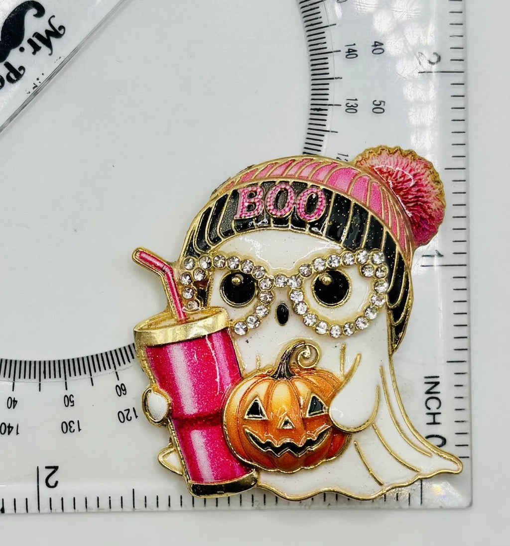 Enamel and crystal ghost girl needle minder beside a ruler for scale