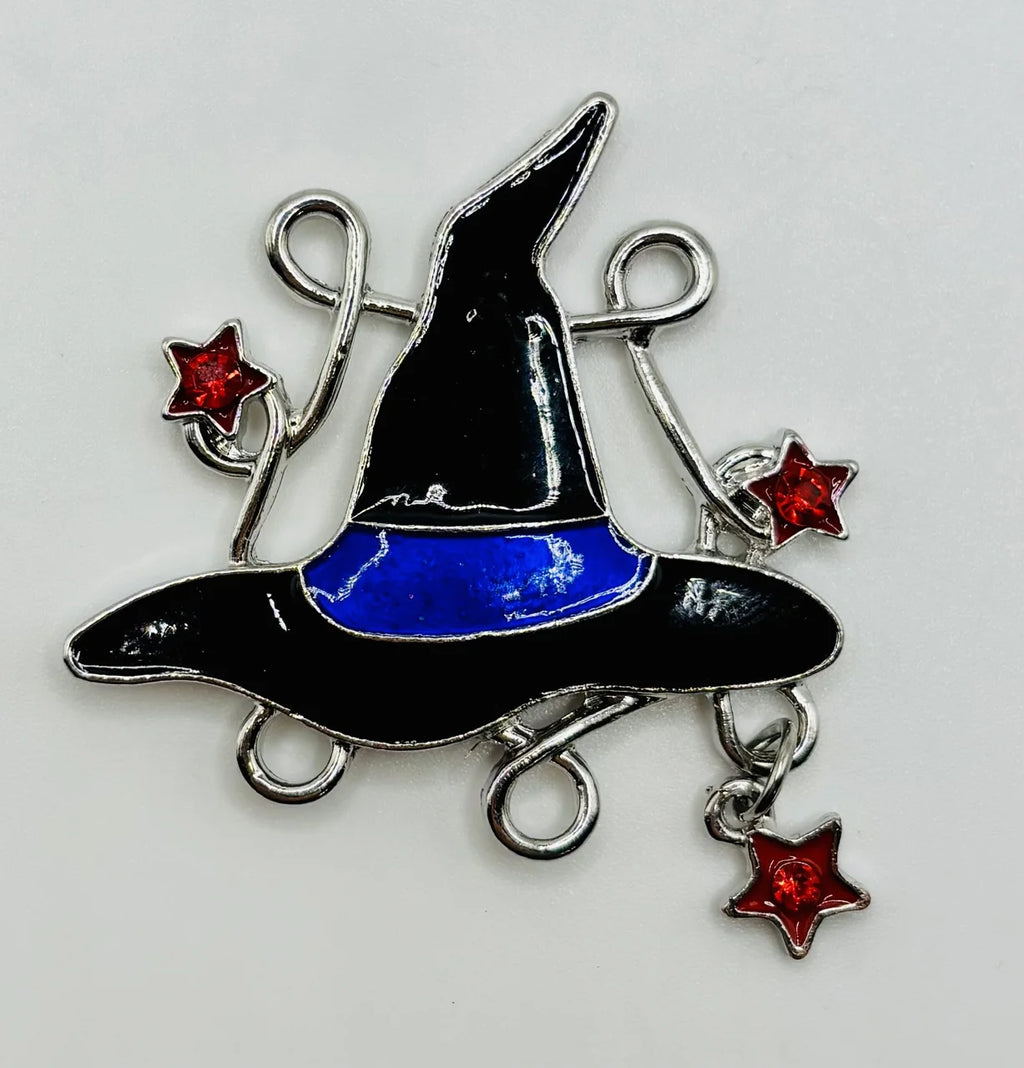 Enamel witch hat with dangling crystals needle minder on a white background