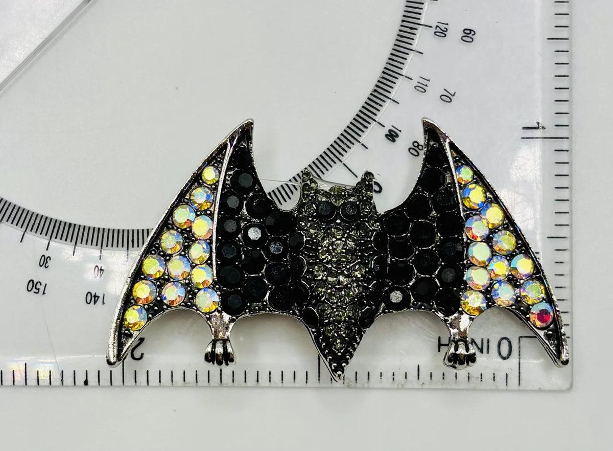 Crystal bat needle minder beside a ruler for scale