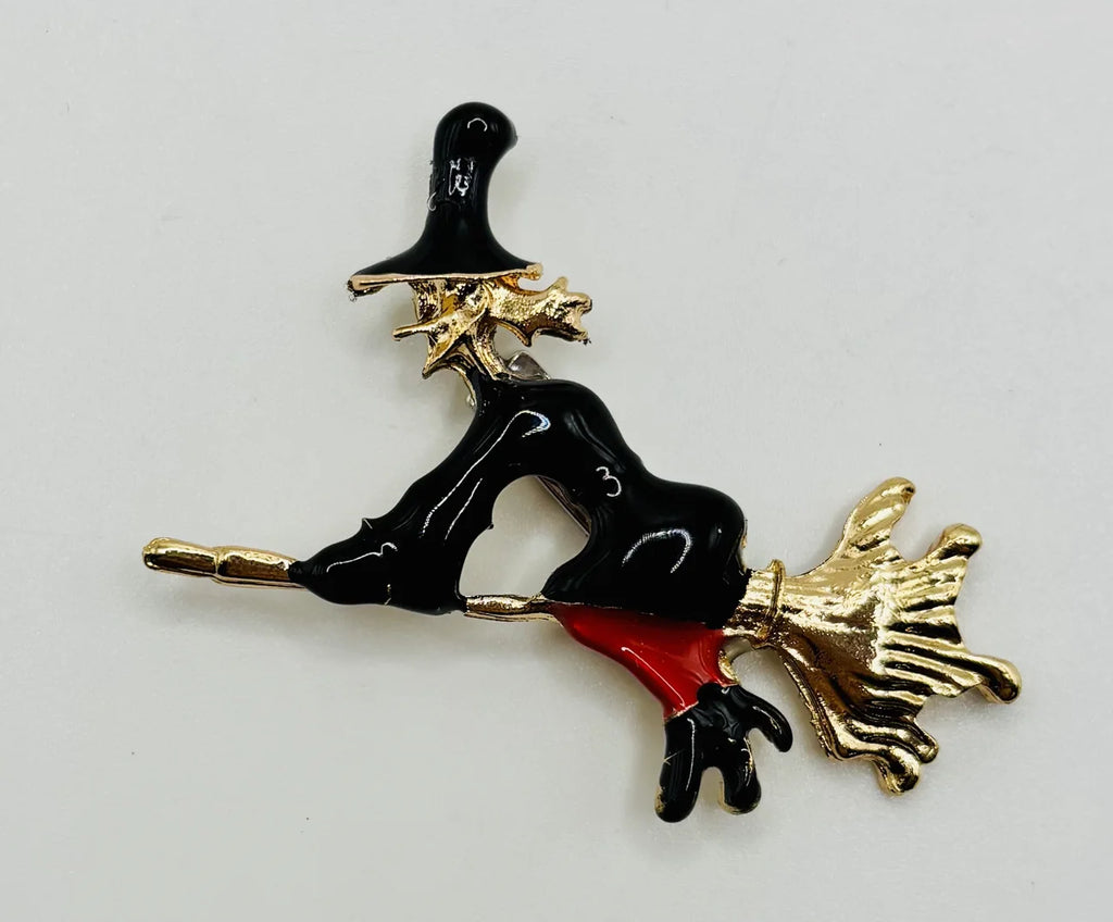 Enamel flying witch needle minder on a white background