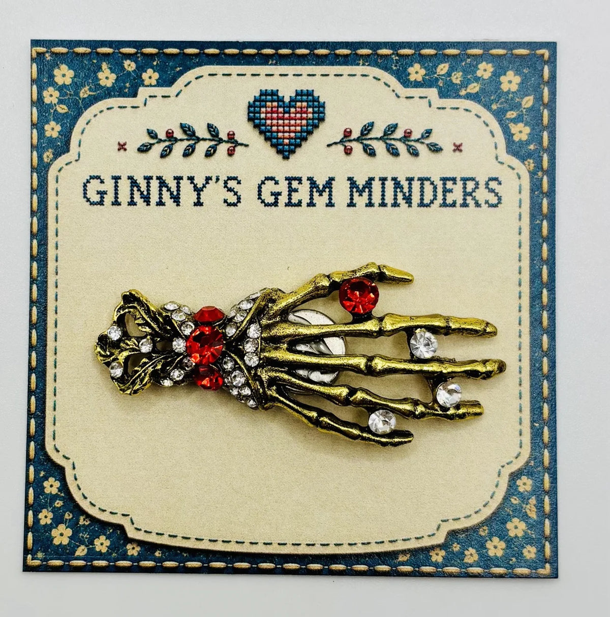 Gold and crystal skeleton hand needle minder on Ginny’s Gem Minders display card
