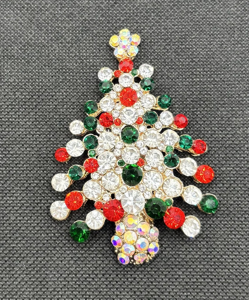 Crystal encrusted tree needle minder on dark fabric