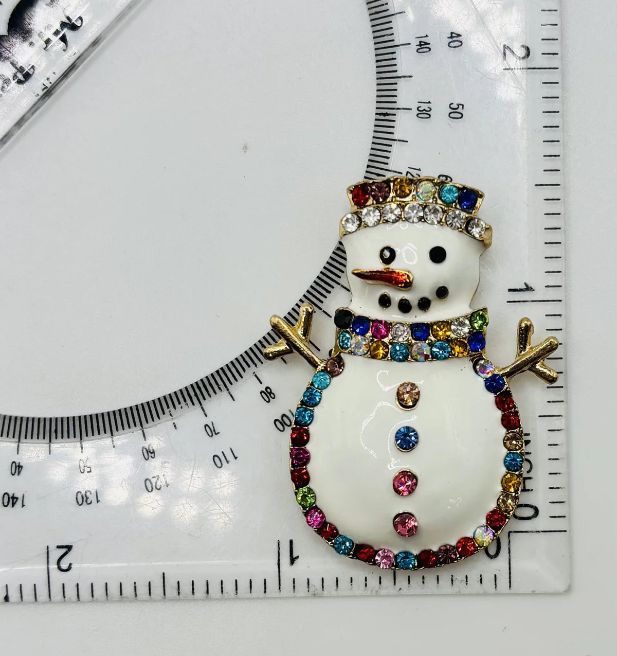 Snowman needle minder beside a ruler for scale