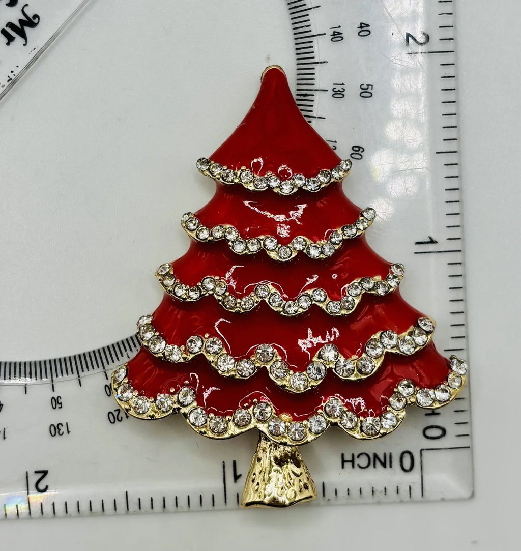 Red enamel tree with crystals needle minder beside a ruler for scale