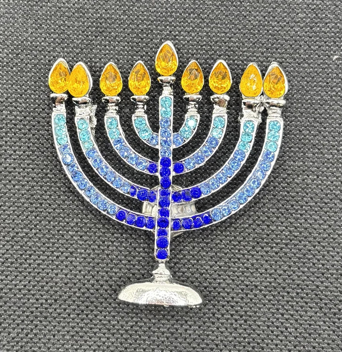 Crystal menorah needle minder on dark fabric