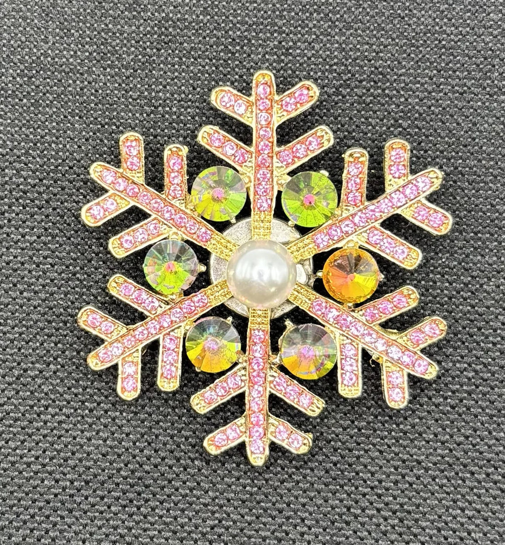 Pink snowflake needle minder on dark fabric