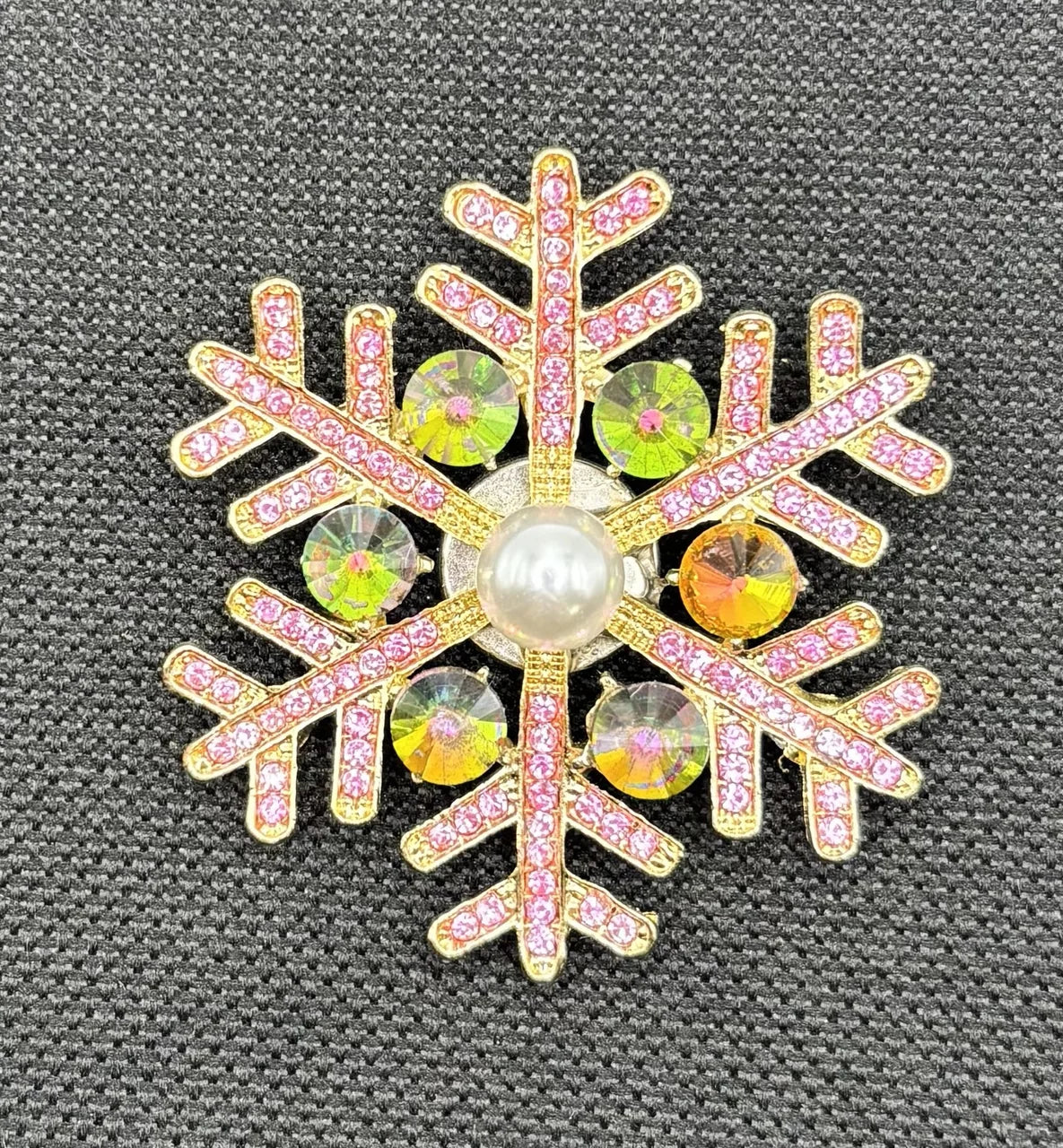 Pink snowflake needle minder on dark fabric