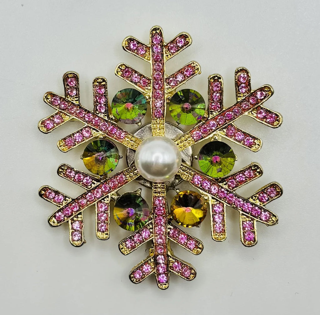 Pink snowflake needle minder on a white background