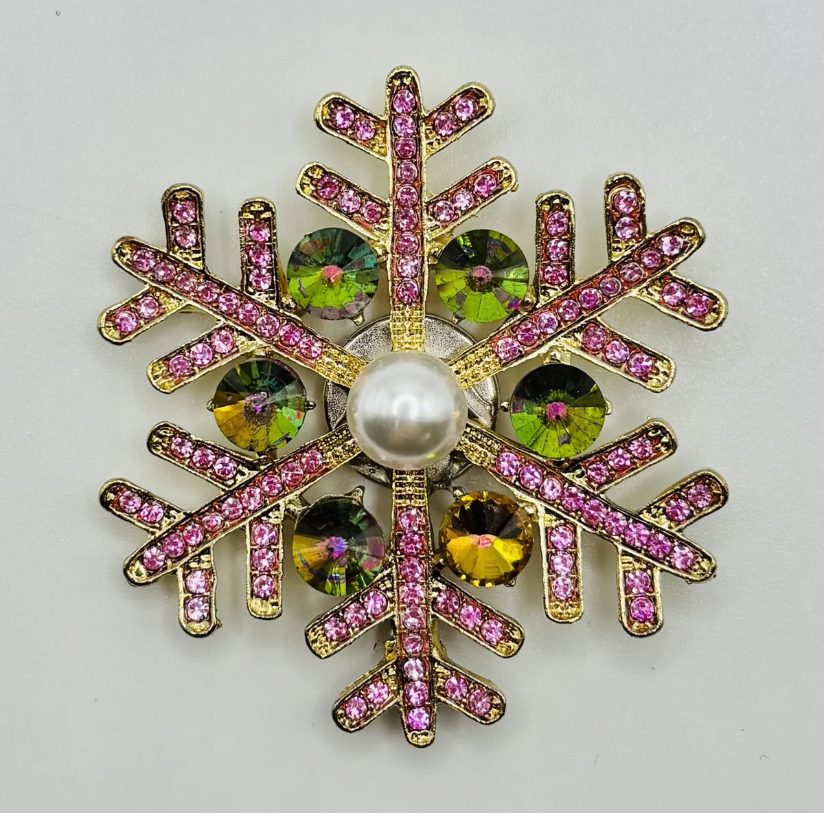 Pink snowflake needle minder on a white background