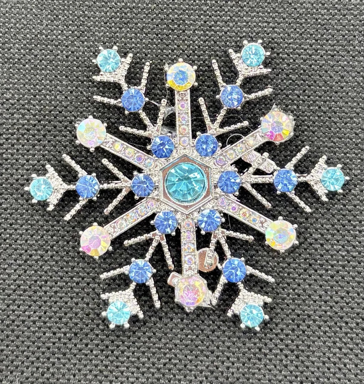 Blue crystal snowflake needle minder on dark fabric