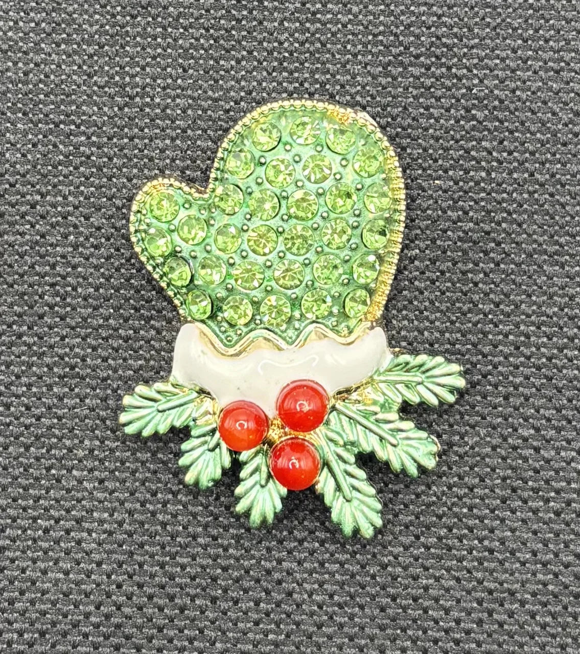 Green crystal mitten needle minder on dark fabric