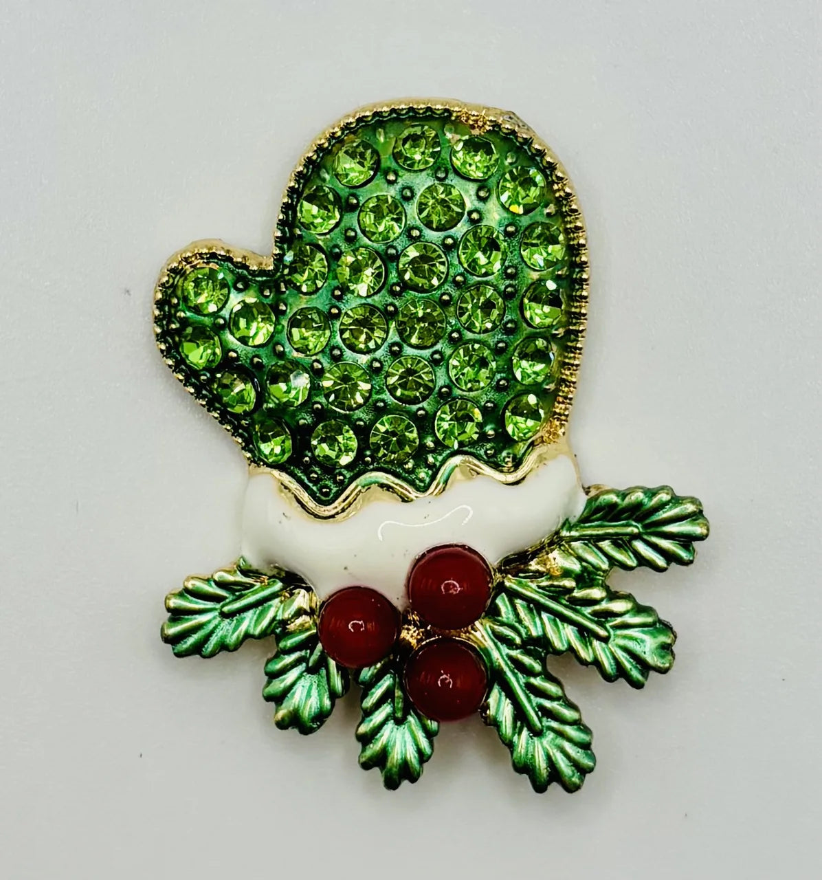 Green crystal mitten needle minder on a white background