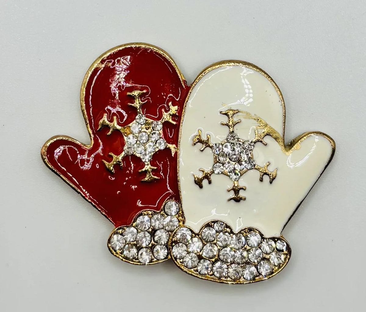 White and red enamel mittens needle minder on a white background