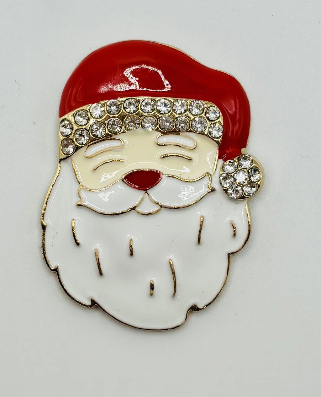 Enamel Santa face needle minder on a white background