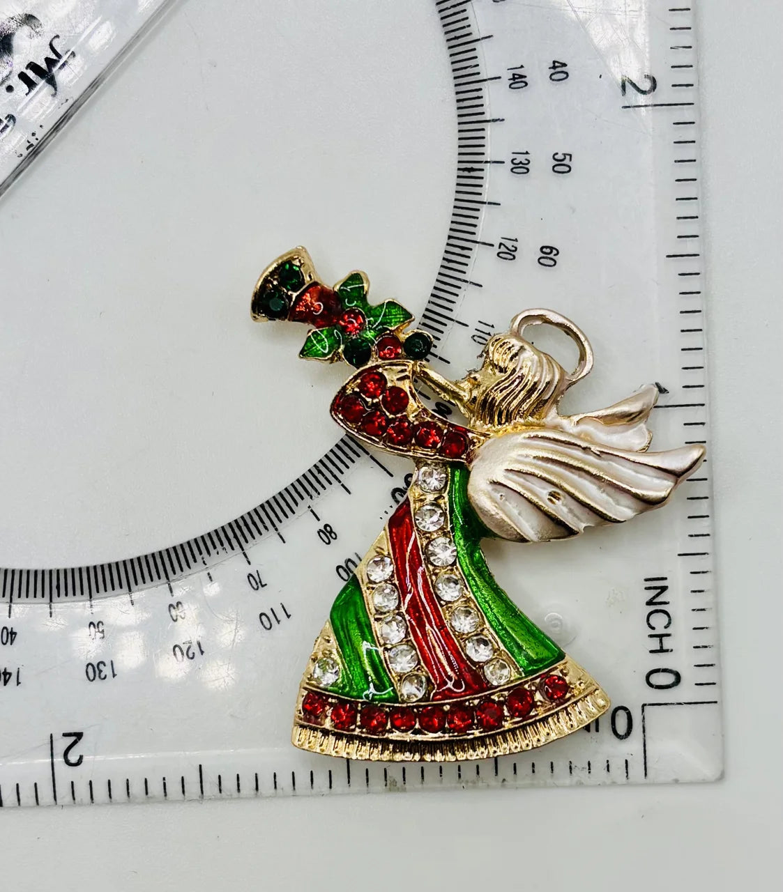 Crystal angel needle minder beside a ruler for scale