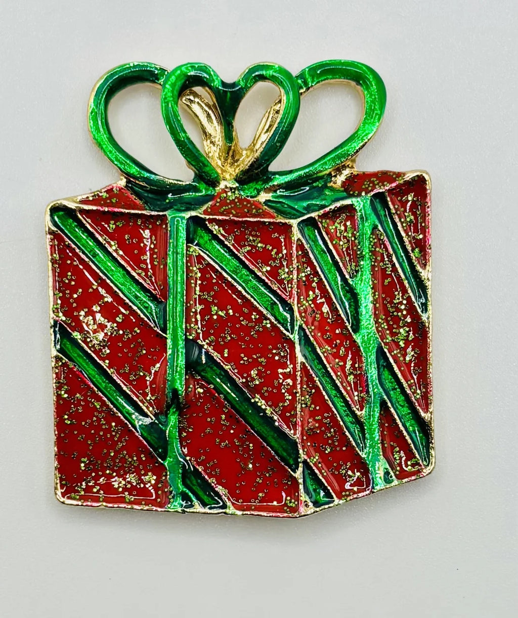 Red enamel present needle minder on a white background